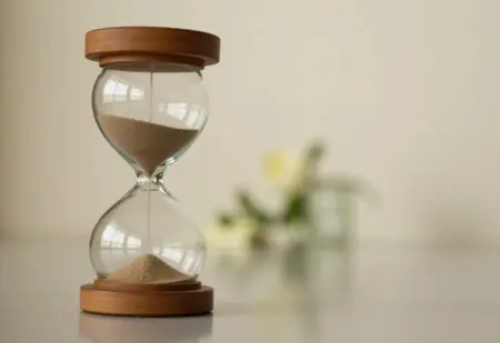 ein symbolisches und respektvolles bild einer sanduhr das den unaufhaltsamen aber friedlichen lauf der zeit in der sterbephase darstellt